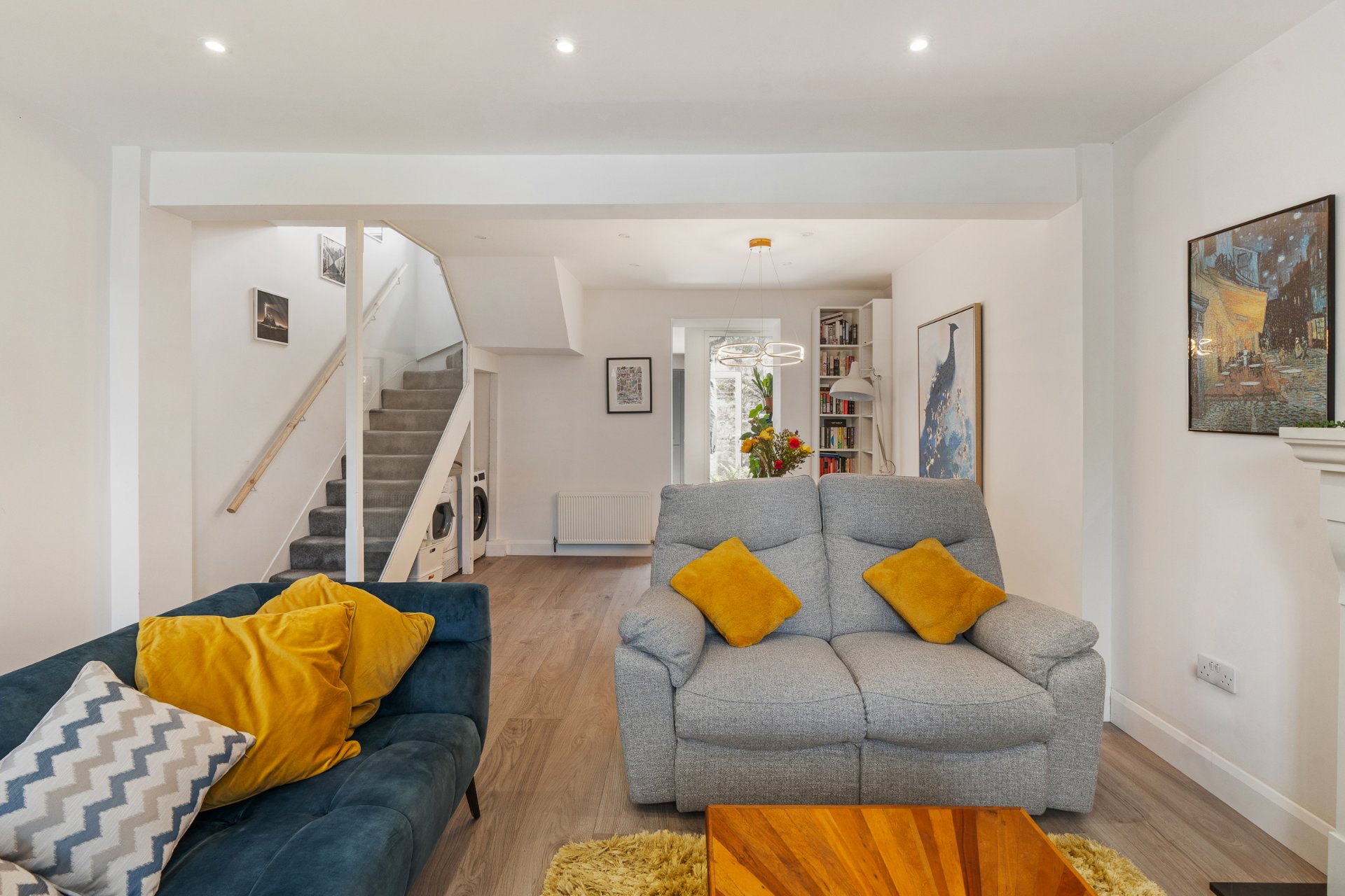The open-plan living and dining room with the staircase and utility tucked beneath.