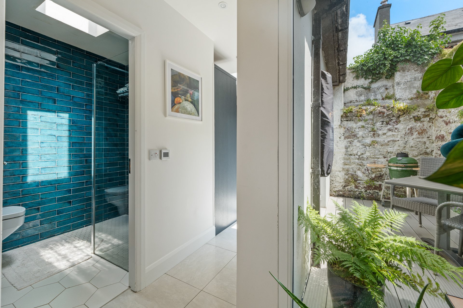 The teal-tiled shower room, opening onto the courtyard.