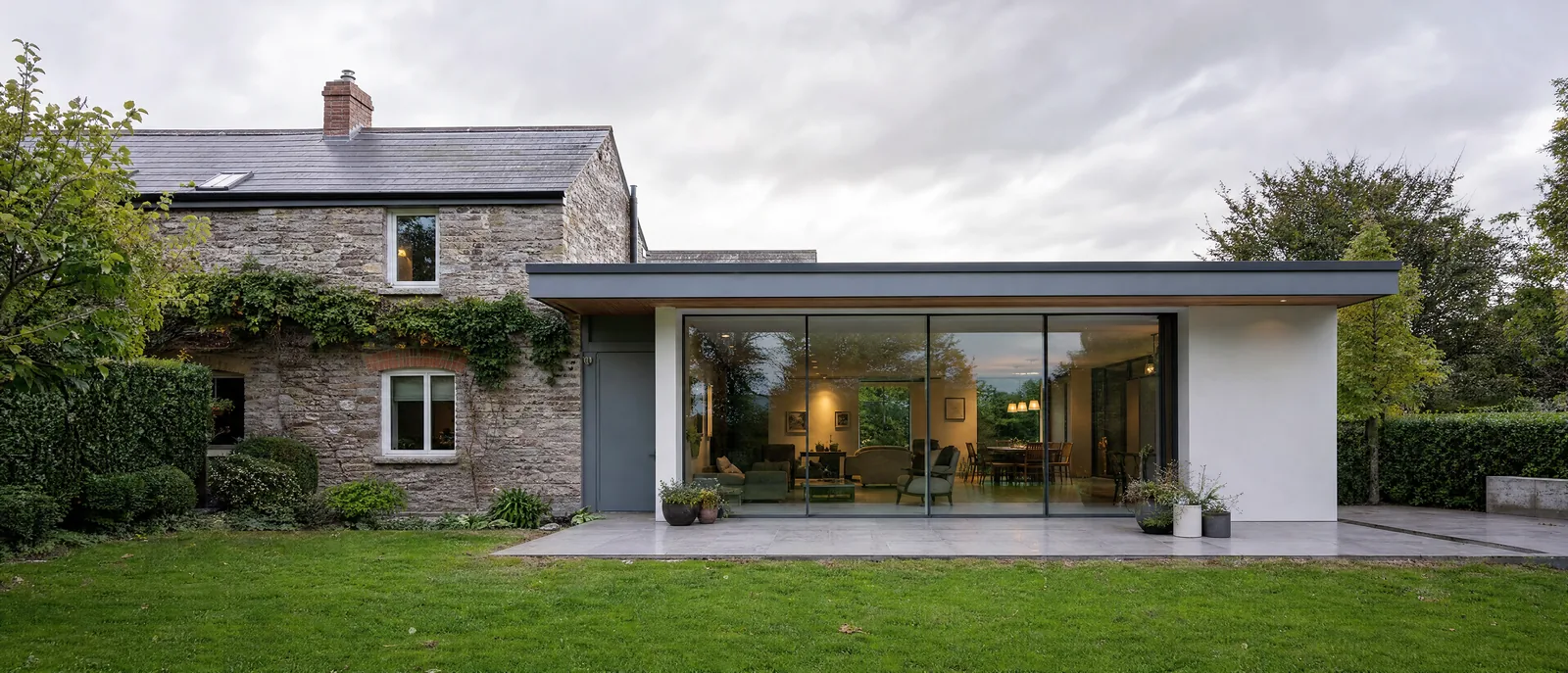 Cork cottage with a modern flat-roof glass extension by TRC Homes